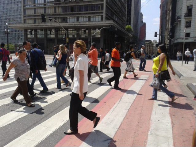 Pessoas atravessam uma faixa de pedestres no centro de São Paulo