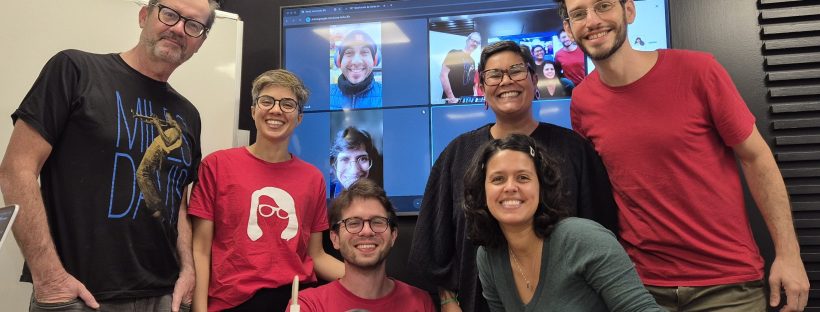 Nova diretoria da Cidadeapé posa numa sala de reunião, com outros membros em videochamada no telão
