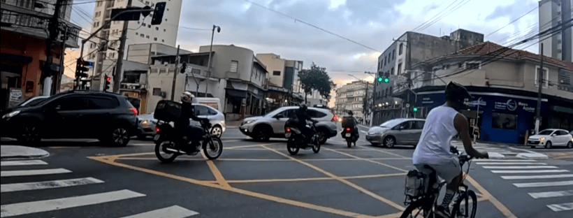 Imagem de reportagem do SP1 sobre multas e acidentes, mostrando cruzamento com motos e ciclista